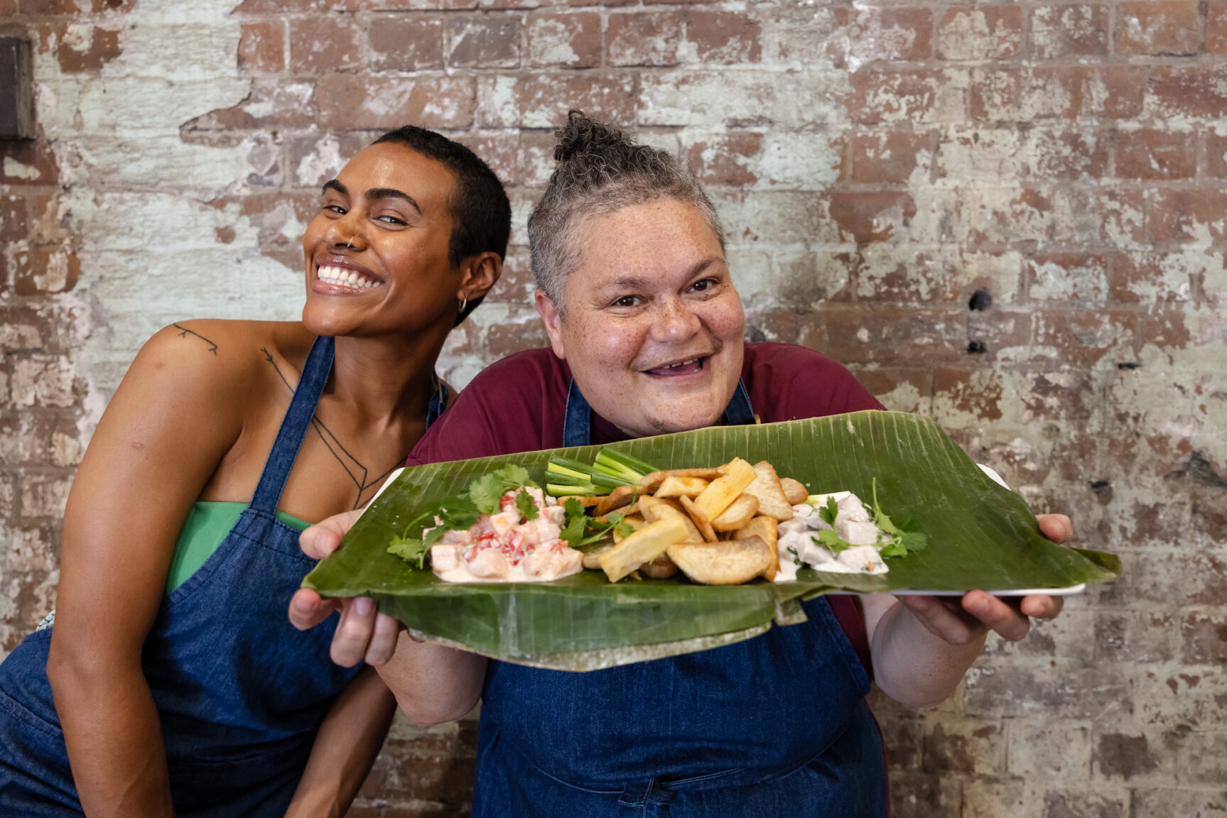 Pasepa Morell and Salote Tawale holding a plate of Fijian food
