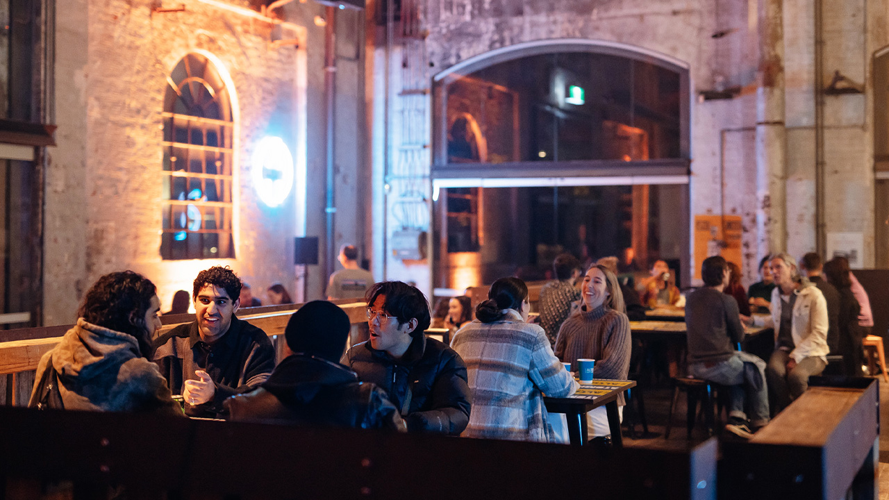 A crowd eats and drinks at the Atomic bar at Carriageworks