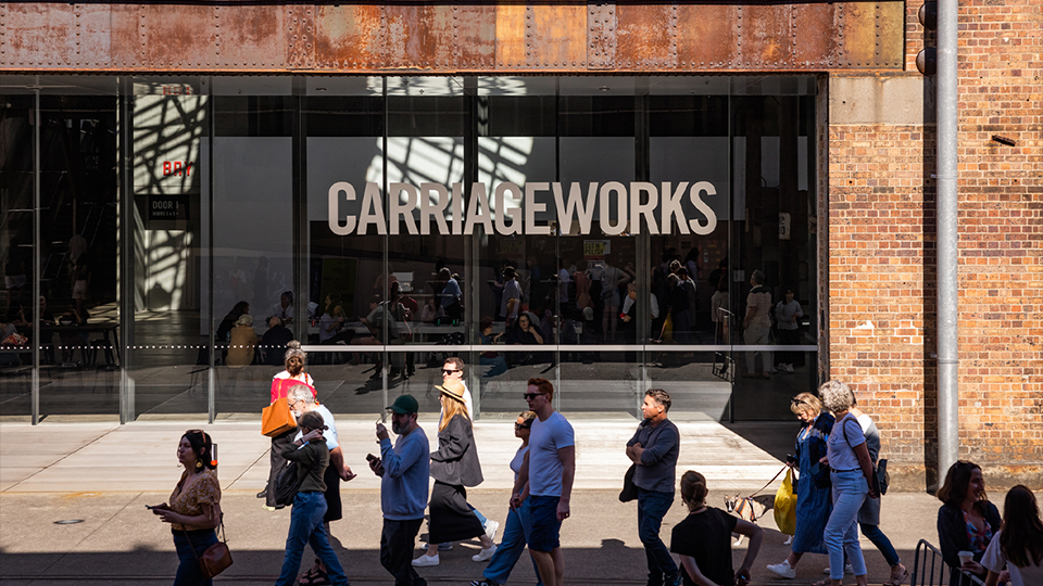 a crowd of people walking past the entrance to Carriageworks