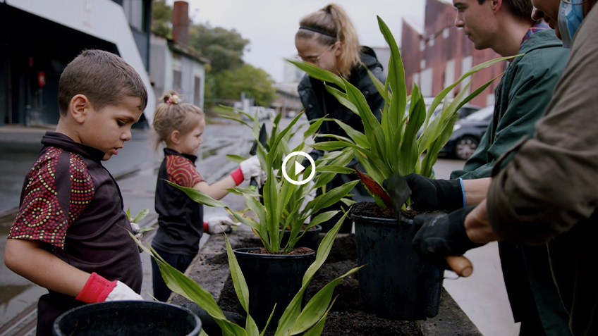 Thumbnail image of Jarjums and Carriageworks staff planting the First Nations Garden