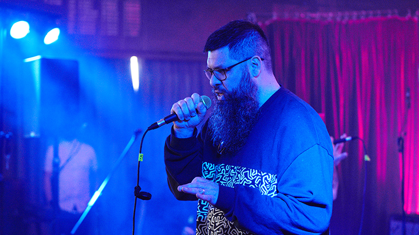 Monks performs on stage bathed in blue light