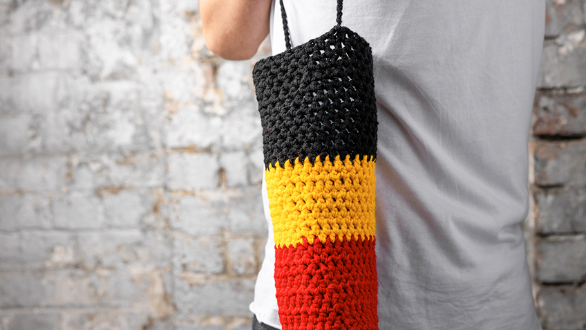 Crochet bag in the colours of the Aboriginal Flag by artist Lucy Connelly - available at Carriageworks' SOUTHEAST Aboriginal Arts Market 2022.