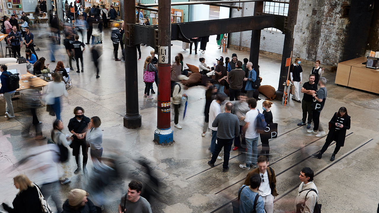 A blurred crowd wanders through the Public Space of Carriageworks during Semi Permanent 2022