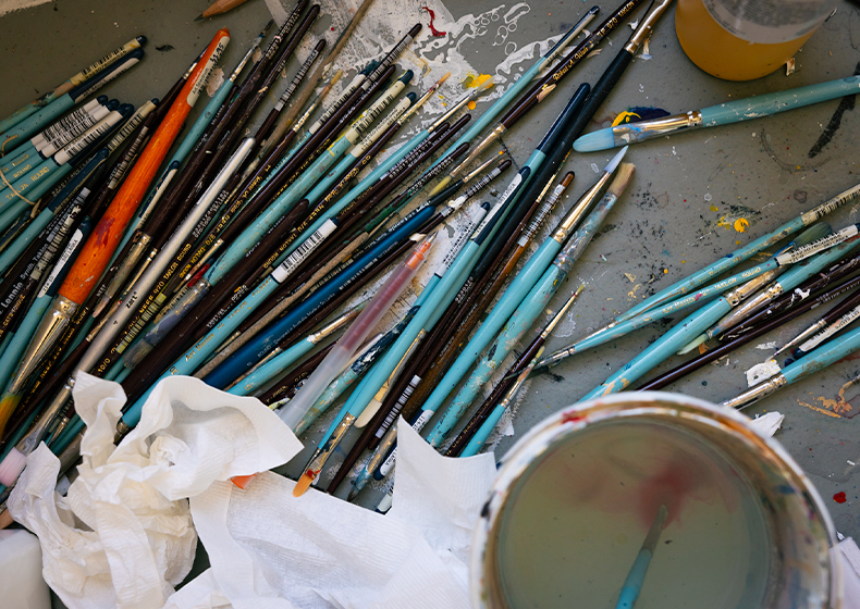 A shot of paintbrushes on a workbench.