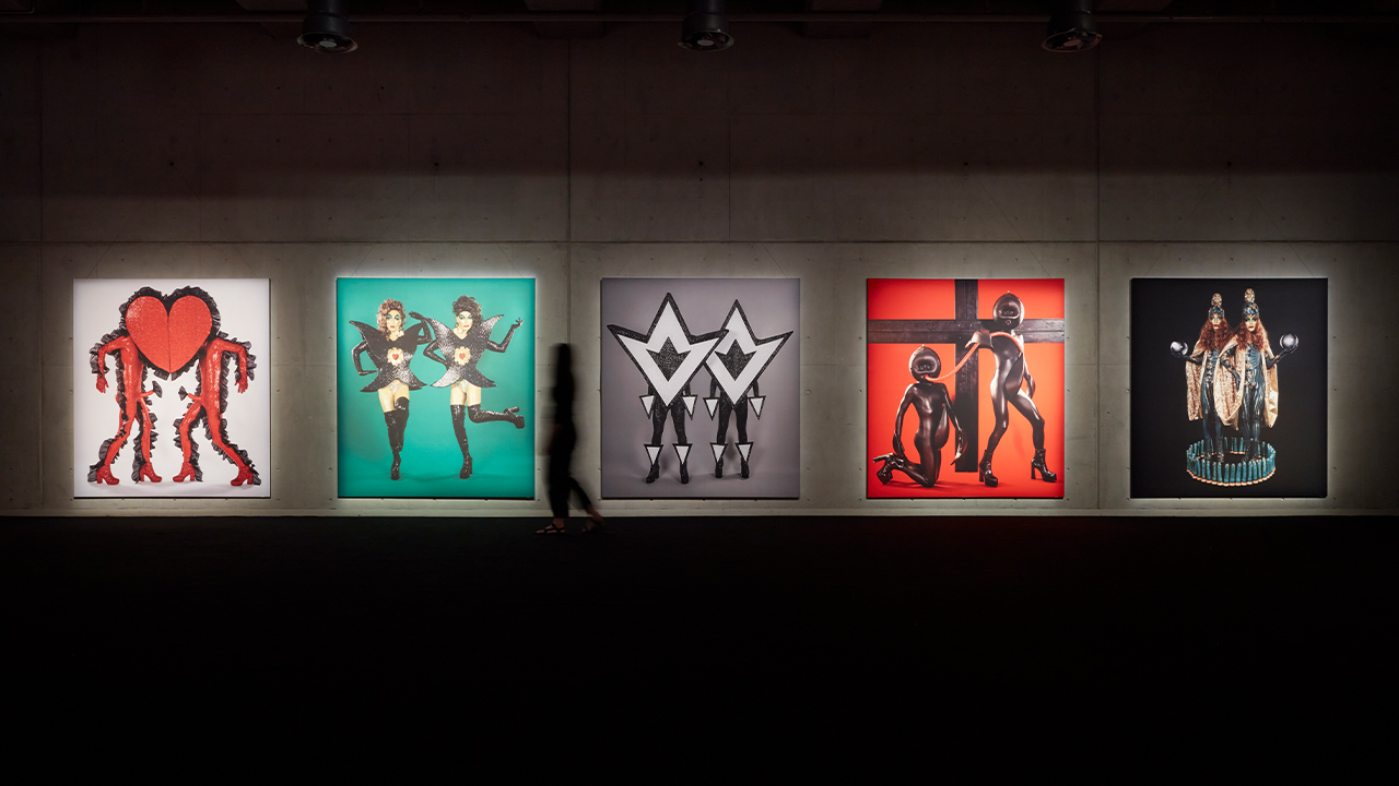 A shadow walks past The Huxleys prints hung on the wall at Carriageworks.