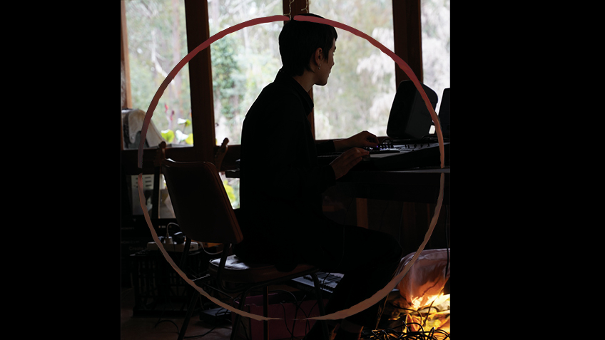 A person sits at decks seen through a round hoop.